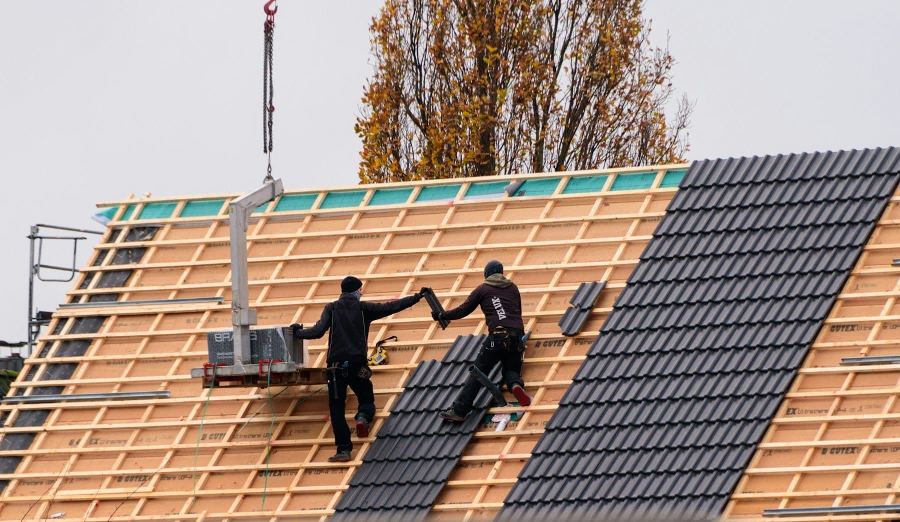 Roofer fitting slates on a pitched roof